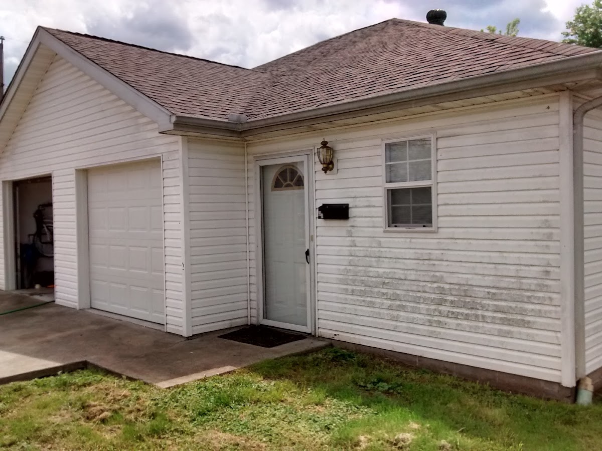 White sided garage and house with mildew ready for a wash