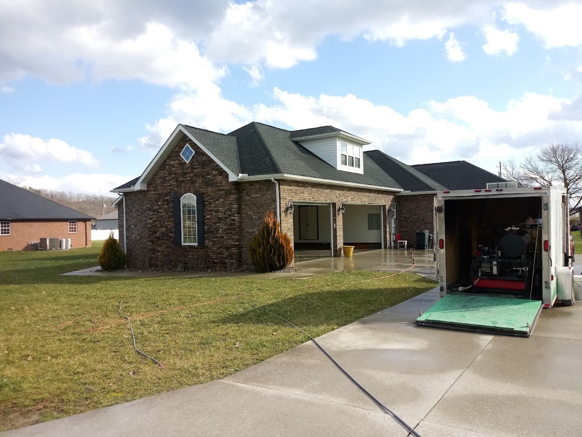 Stone front home with the McGinnis wash trailer on the driveway